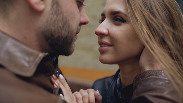 Close-up van een gelukkig liefdevol paar dat zoent en omhelst terwijl ze door de stadsstraat loopt