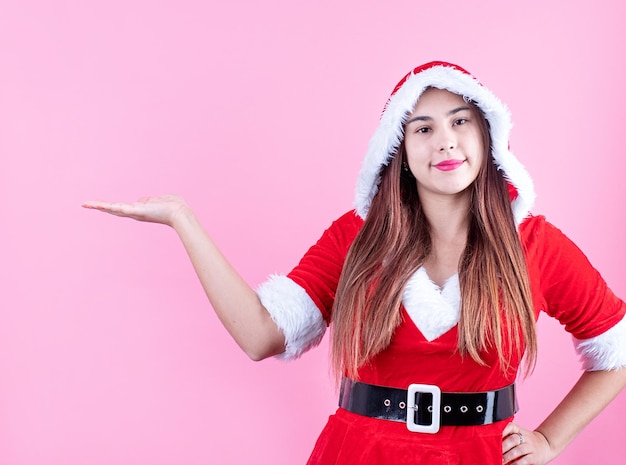 Close-up van een gelukkige blanke vrouw die kerstkleren draagt, glimlachend en wijzend met de vinger