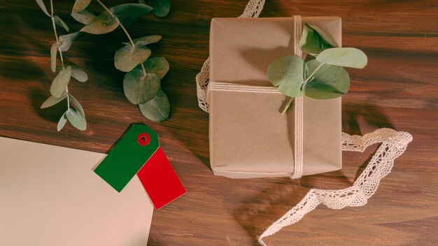 Foto close-up van een geschenkdoos en twee gekleurde etiketten op een lege brief op een houten achtergrond