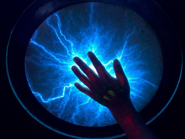 Foto close-up van een geschilderde hand op verlichte apparatuur