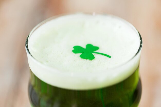 Close-up van een glas groen bier met shamrock