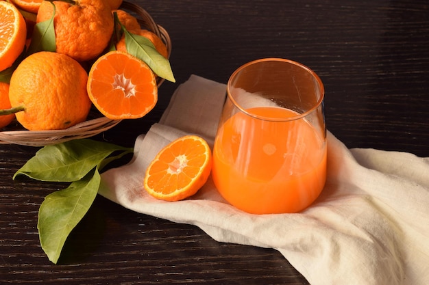 Close-up van een glas vers en heerlijk mandarijnensap met bladeren