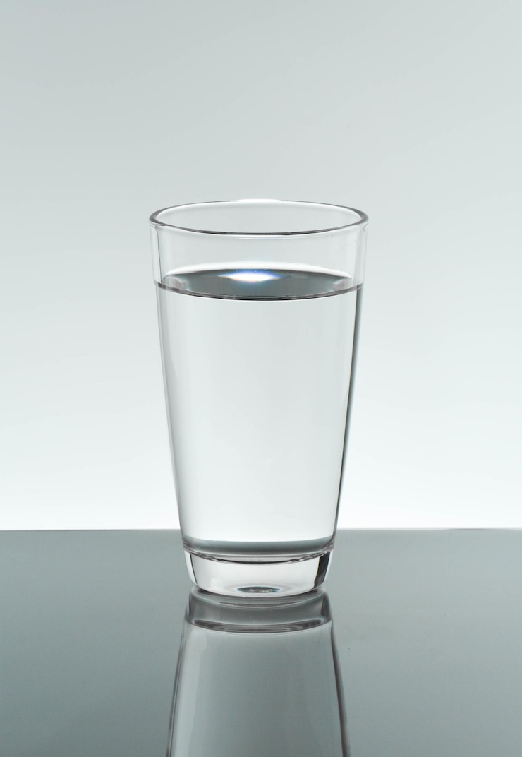 Foto close-up van een glas water tegen een witte achtergrond