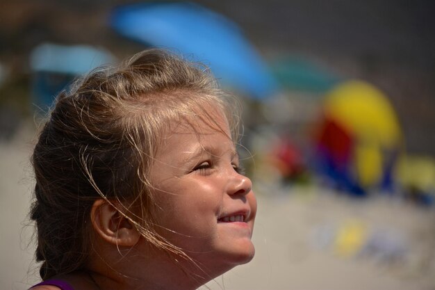 Foto close-up van een glimlachend meisje op het strand