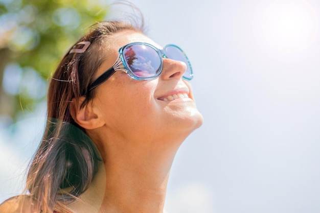 Close-up van een glimlachende vrouw die omhoog kijkt