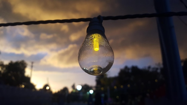 Foto close-up van een gloeilamp die tegen de lucht hangt