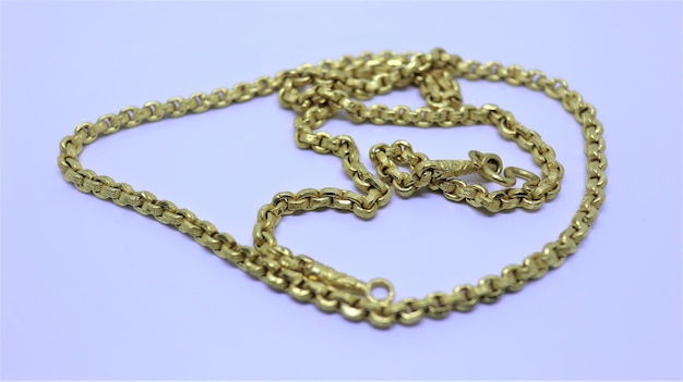 Foto close-up van een gouden ketting halsketting op witte achtergrond