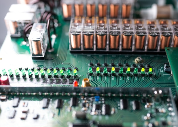 Close-up van een grote groene microschakeling en lichtgevende panelen in een fabriek voor radio-onderdelen. complex elektronisch apparatuurconcept in een fabriek