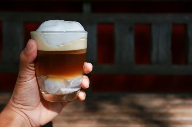 Foto close-up van een hand die een bierglas vasthoudt