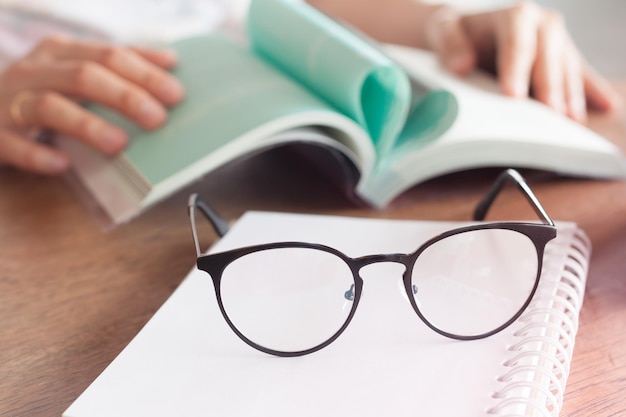 Foto close-up van een hand die een boek op tafel houdt