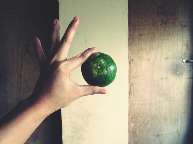 Foto close-up van een hand die een citrusvrucht vasthoudt