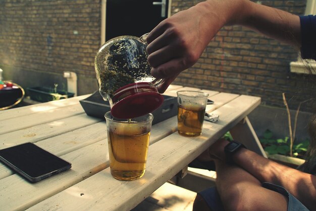 Foto close-up van een hand die een koffiebeker op tafel houdt