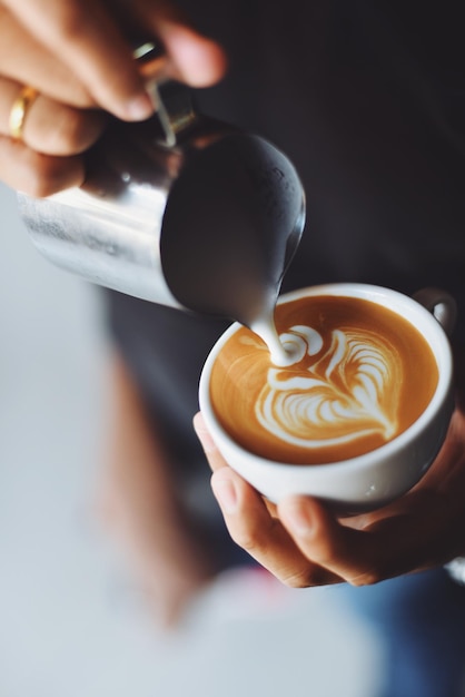 Close-up van een hand die een koffiebeker vasthoudt