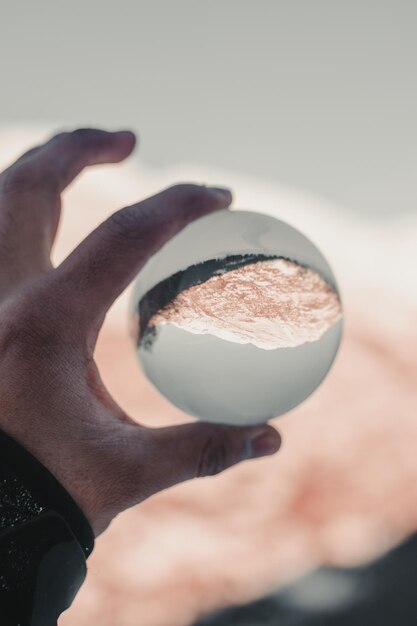 Foto close-up van een hand die een kristallen bol vasthoudt