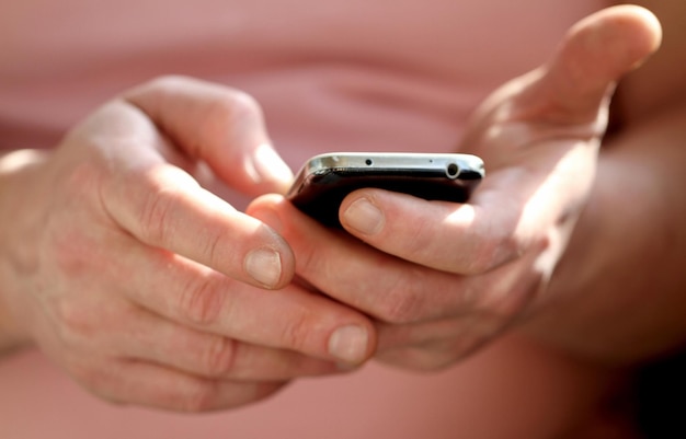 Close-up van een hand die een mobiele telefoon vasthoudt