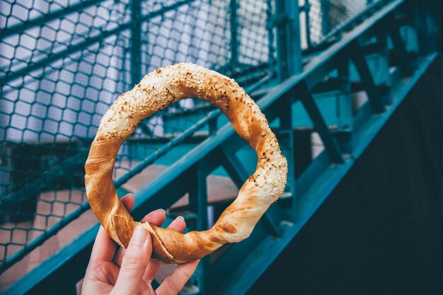 Foto close-up van een hand die een pretzel vasthoudt