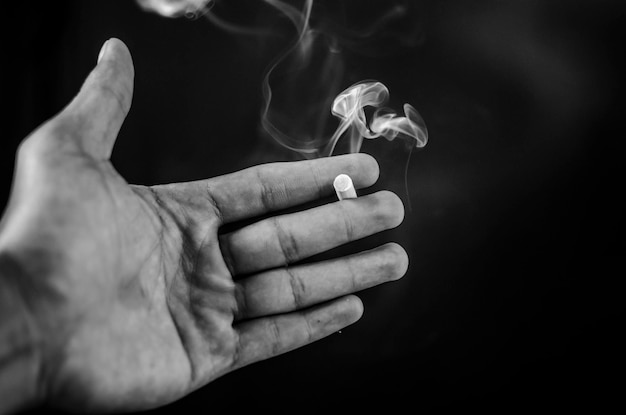 Foto close-up van een hand die een sigaret vasthoudt