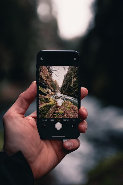 Foto close-up van een hand die een smartphone vasthoudt en een foto maakt