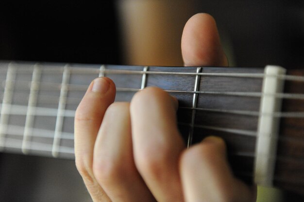 Close-up van een hand die gitaar speelt