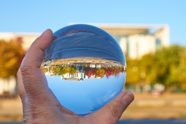 Foto close-up van een hand die glas vasthoudt tegen de lucht