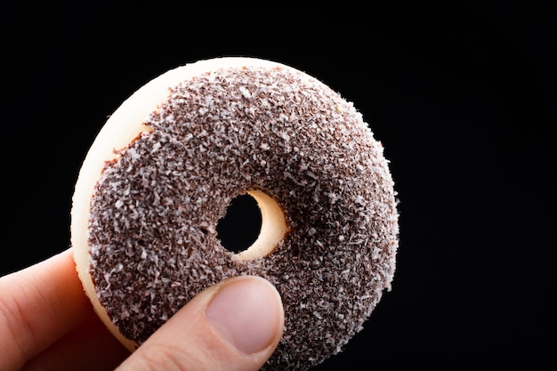 Foto close-up van een hand die ijs vasthoudt op een zwarte achtergrond