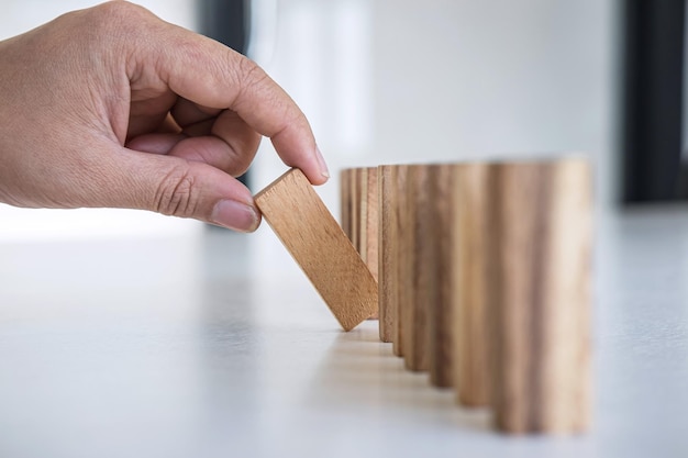 Foto close-up van een hand die met speelgoedblokken op tafel speelt