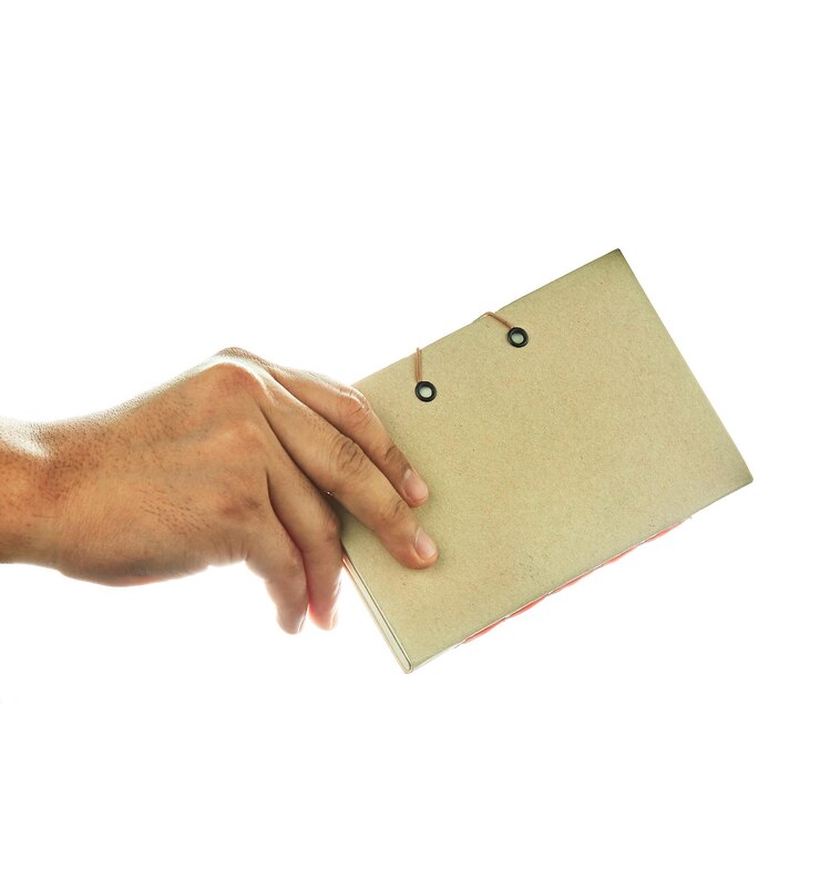 Foto close-up van een hand die papier vasthoudt tegen een witte achtergrond