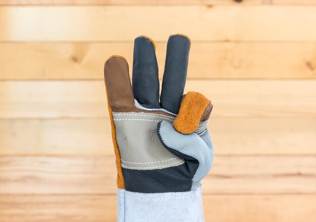 Foto close-up van een hand met een beschermende handschoen op tafel