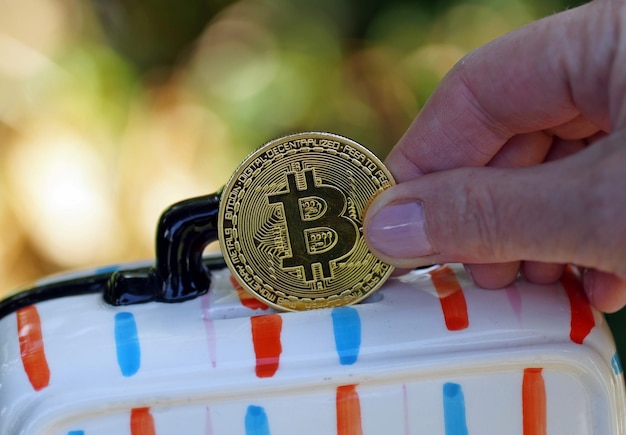 Close-up van een hand met gele munt met een bitcoin-teken