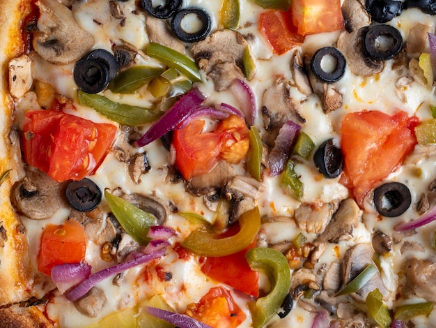 Close-up van een heerlijke vegetarische pizza met groenten en champignons Achtergrond van voedsel Bovenaanzicht selectieve focus ongezond voedsel