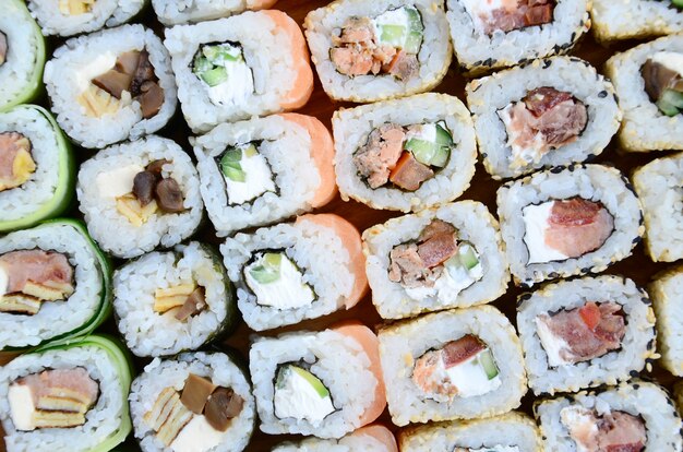 Close-up van een heleboel sushi rollen met verschillende vullingen.