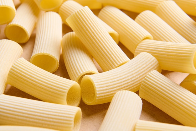 Close-up van een hoop ongekookte volkoren tortiglioni Italiaanse pasta. Pasta patroon. Voedsel achtergrond