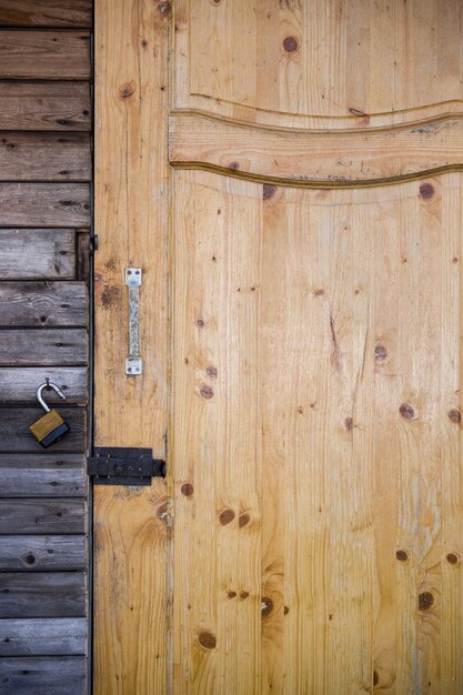 Close-up van een houten deur met een slot in een oud tuinhuis