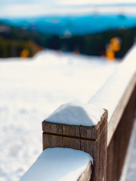 Foto close-up van een houten paal in de sneeuw