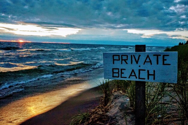 Foto close-up van een informatiebord op het strand tegen de lucht