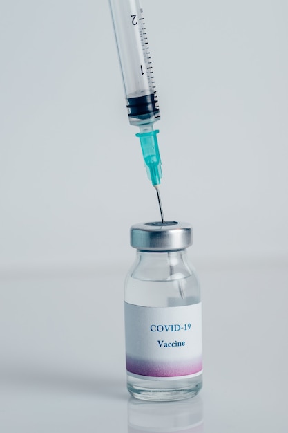Close-up van een injectieflacon met COVID-19-vaccin en een spuit