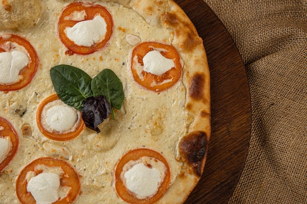 Close-up van een Italiaanse pizza met prosciutto ham, groene olijven en rucola