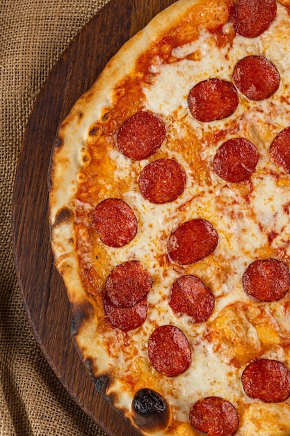Close-up van een Italiaanse pizza met prosciutto ham, groene olijven en rucola