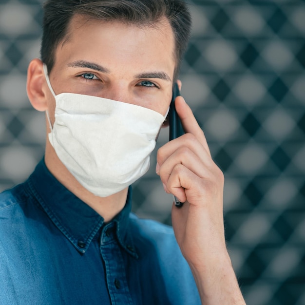 Close-up van een jonge man met een beschermend masker die naar je foto kijkt met een copyspace