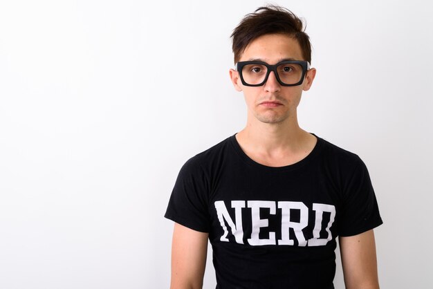 Foto close up van een jonge nerd man met bril tegen witte rug