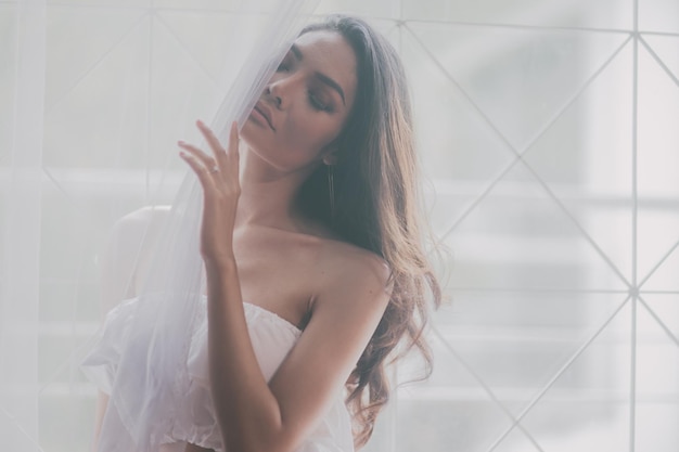 Close-up van een jonge vrouw bij het raam gordijn thuis
