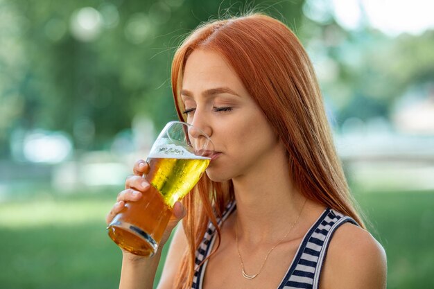 Foto close-up van een jonge vrouw die bier drinkt.