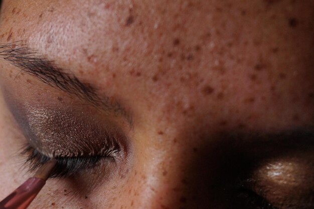 Foto close-up van een jonge vrouw die make-up maakt