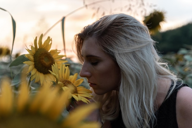 Close-up van een jonge vrouw die zonnebloem ruikt op een boerderij