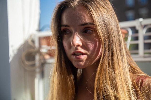 Foto close-up van een jonge vrouw met blond haar die wegkijkt.