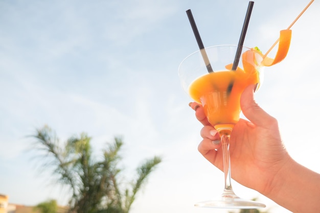 Close-up van een jonge vrouw met drank tegen de lucht