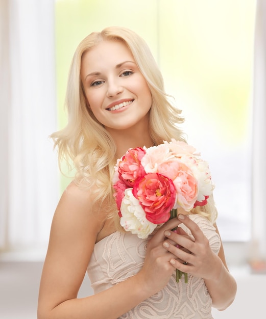 Close-up van een jonge vrouw met een boeket bloemen.