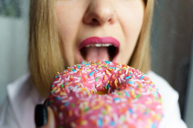 Foto close-up van een jonge vrouw met een donut.