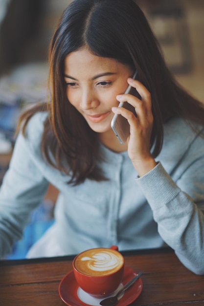 Close-up van een jonge vrouw met een mobiele telefoon.