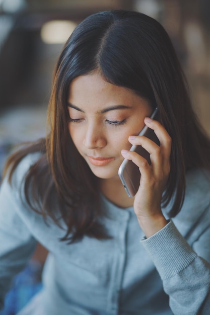 Close-up van een jonge vrouw met een mobiele telefoon.
